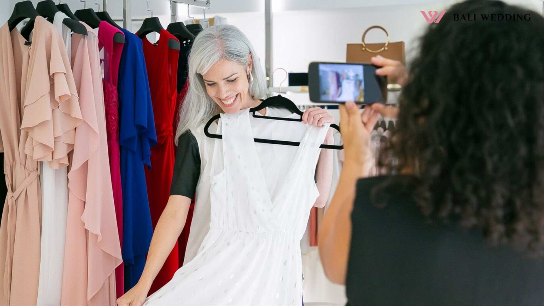 Cheerful female shoppers enjoying shopping in clothes store together