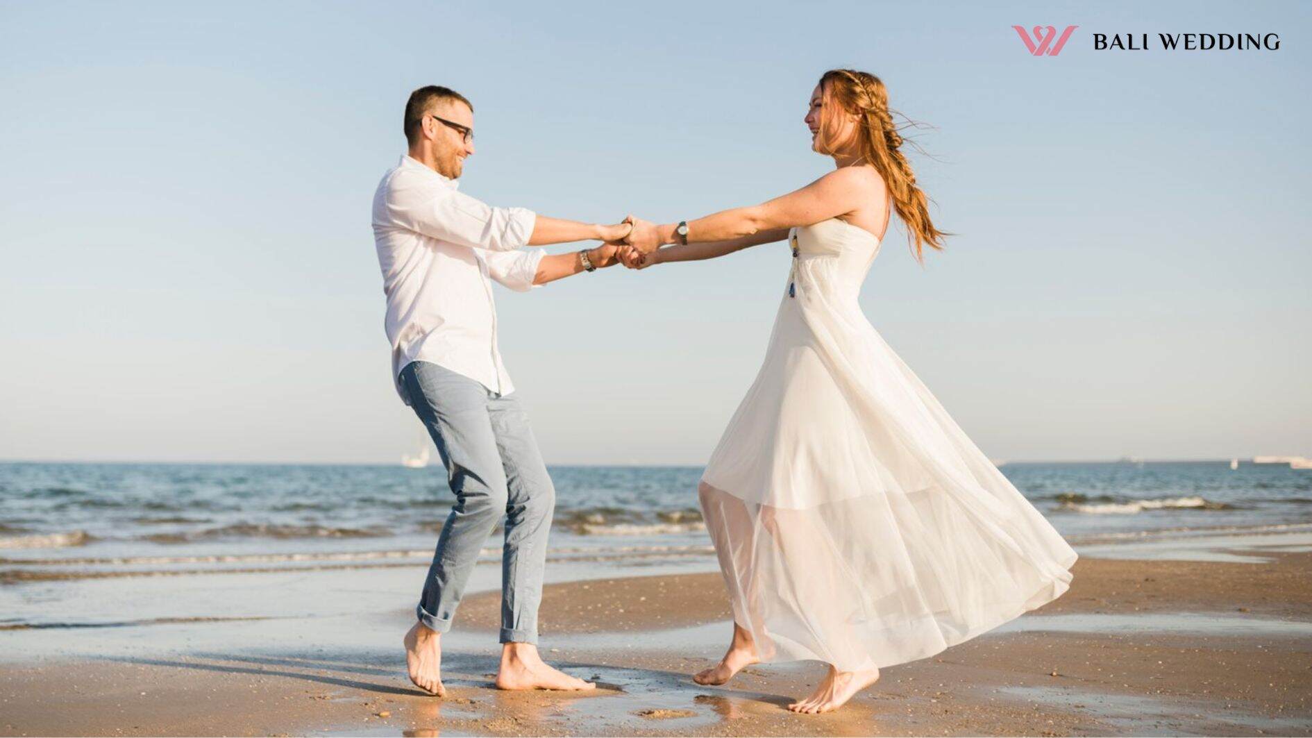 Lovely young couple dancing together near the seacoast at beach